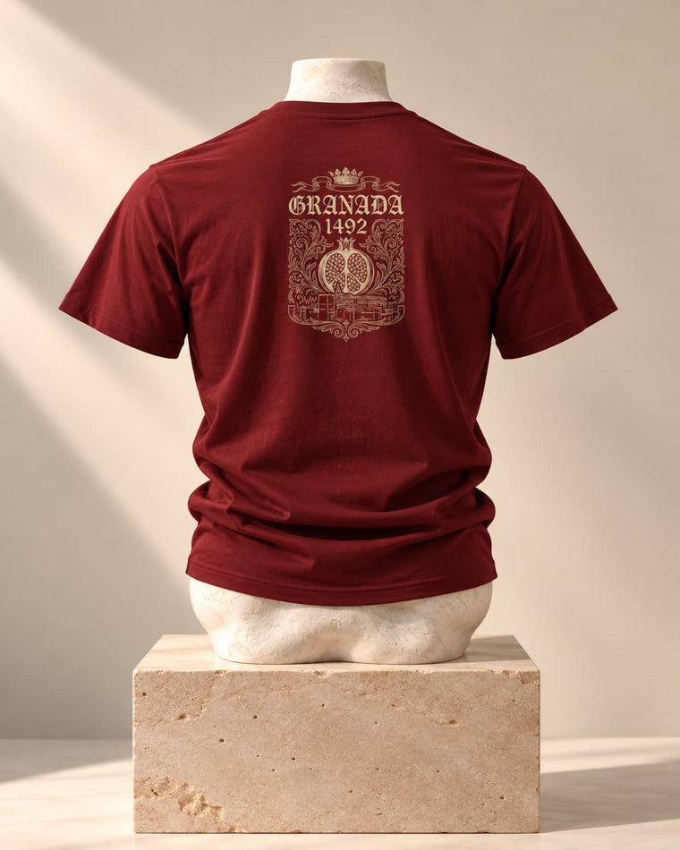 Camiseta Granada 1492 en burdeos, vista de espaldas, sobre un busto de piedra y un pedestal de travertino