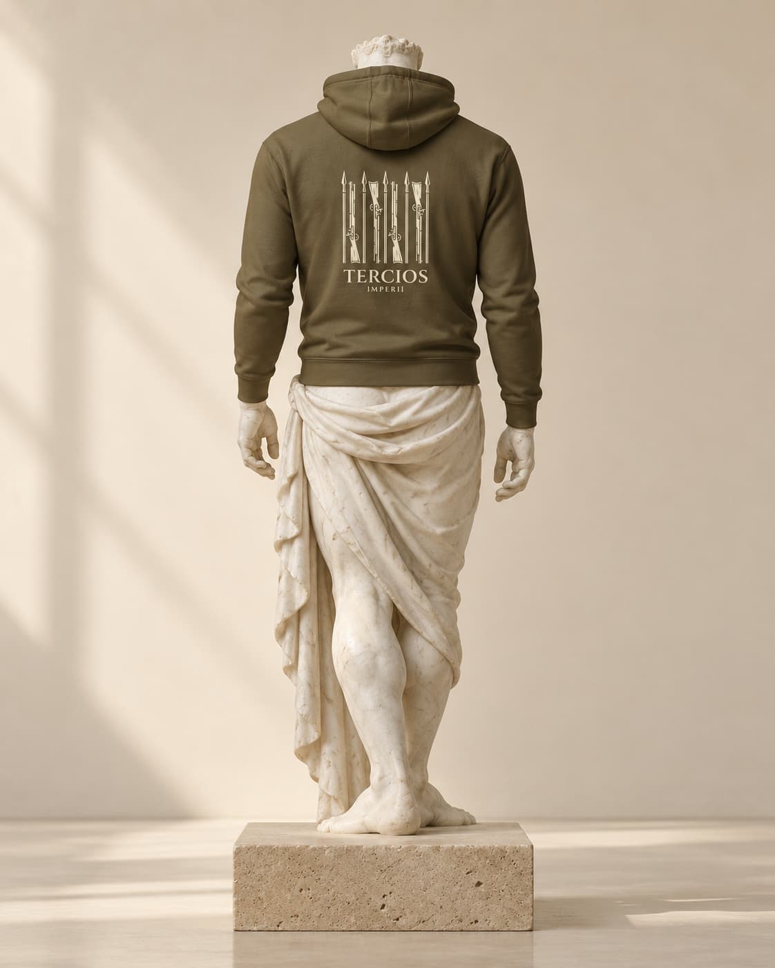 Sudadera Tercios Imperii verde con capucha, de espaldas, sobre una estatua de mármol y un pedestal de travertino